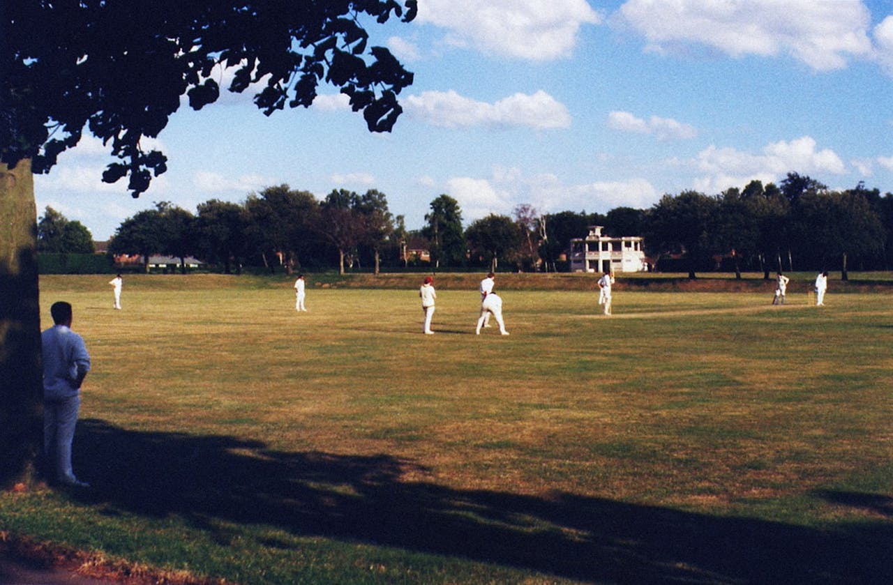 A cricket match being played on a sunny day in Norwich, showcasing players in action.